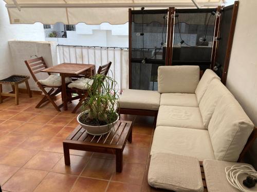 een woonkamer met een bank en een tafel bij La Hacienda Golf Islantilla con Wifi y Aire Ac SOLO PAREJAS Y FAMILIAS in Islantilla