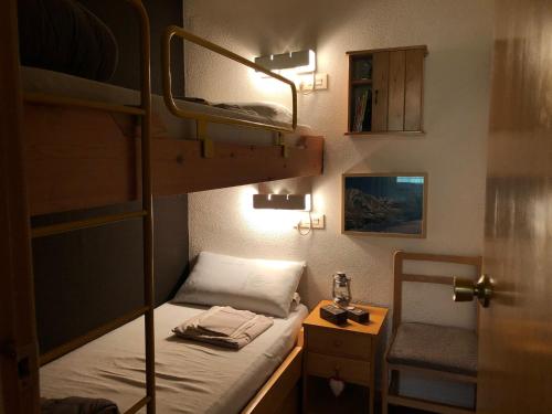 um pequeno quarto com um beliche e uma mesa de cabeceira em CHECK-IN CASAS Cerler 3F em Cerler