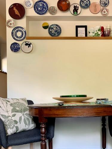 a table with plates on the wall and a bowl on it at Vakantiehuis ABEL in Dilsen-Stokkem