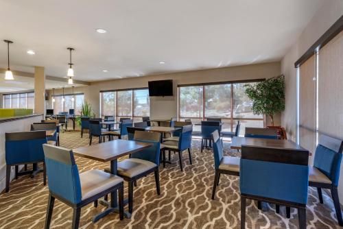 Un comedor con mesas y sillas y un televisor de pantalla plana. en Comfort Suites Fernley, en Fernley