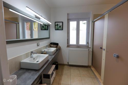 Thiergevilleにあるla grange aux hortensiasの洗面台が2つと鏡があるバスルーム