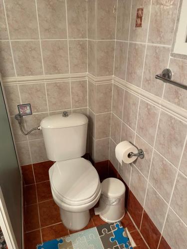 a bathroom with a toilet in a tiled room at Sweet dreams at the seaside in Skála Foúrkas