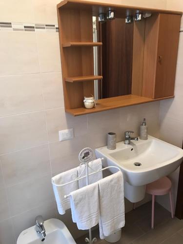a bathroom with a sink and a toilet with towels at Gloria Apartment in Baveno