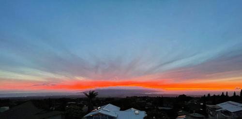 a sunset over a city with a red sky at Ha'le Kiana in Kula