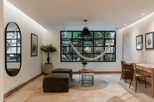 sala de estar con mesa, sillas y ventanas en Villaz Luxury Vacation Homes, en Medellín