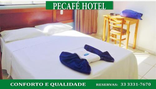 a hotel room with a bed with a robe on it at Pecafe Hotel in Manhuaçu