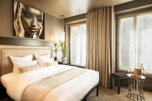 a bedroom with a large white bed and a window at B Montmartre in Paris