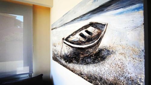 a painting of a boat on a wall at Tessera Villas & Studios Collection in Gouvia