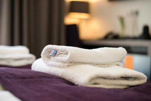 Una pila de toallas encima de una cama en Trip Inn Goethe Business Messe, en Frankfurt