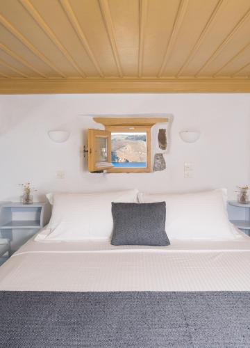 a white bed in a room with a window at Kalderimi Residencies in Astypalaia Town
