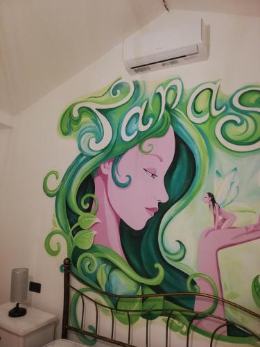 a mural on a wall in a bedroom at Casa Janas Affittacamere Bed & Breakfast in Piscinas