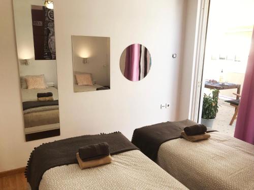 a bedroom with two beds and a mirror at Athens by foot: Perfect flat with terrace in Athens