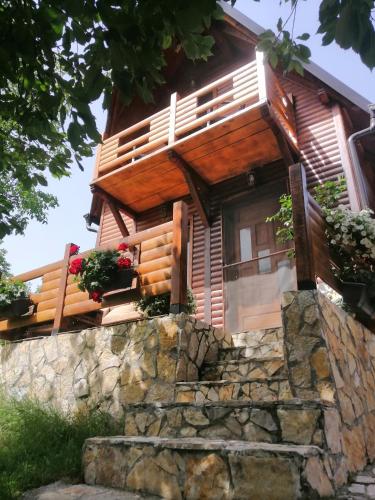 a log cabin with potted plants on a stone wall at Brvnara Fruska Koliba in Vrdnik
