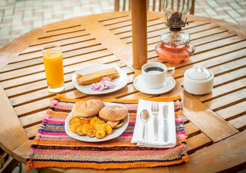 een tafel met een bord ontbijtproducten en jus d'orange bij Hotel Tartar in Cajamarca