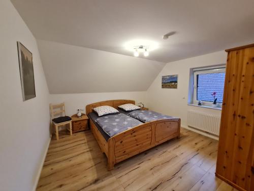 a bedroom with a wooden bed and a window at Ferienhaus Taucherperle in Hemmoor