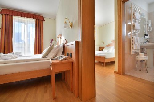 a bedroom with a bed with a window and a bed sidx sidx sidx at Hotel Interalpen in Valdidentro