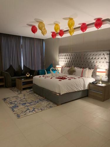 a bedroom with a bed with balloons hanging from the ceiling at The Address Palace Apartments in Dammam