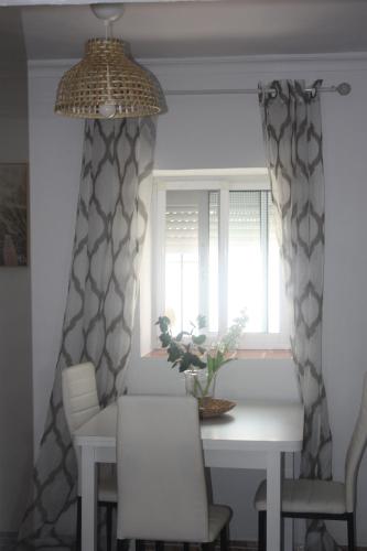 a dining room table with chairs and a window at La Moradita in Vejer de la Frontera