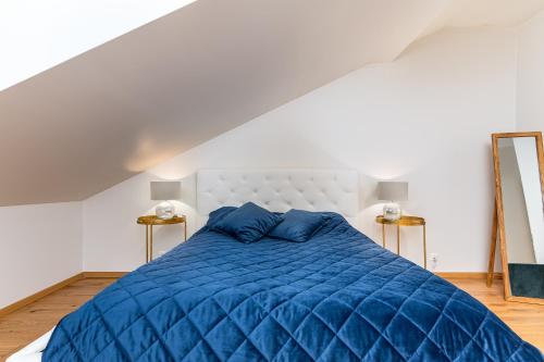 a bedroom with a blue bed with blue pillows at Lossi Old Town Apartment in Tartu