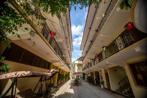 un callejón vacío entre dos edificios con mesas en Hotel Chveni Ezo, en Kobuleti