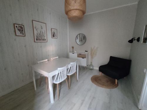 une salle à manger avec une table et des chaises blanches dans l'établissement Le coin des Sables, à Les Sables-dʼOlonne
