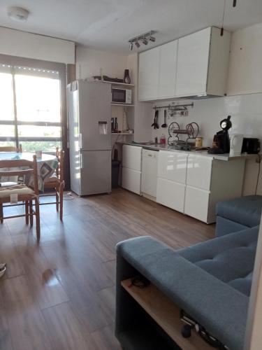 une cuisine avec des placards blancs et un canapé bleu dans l'établissement Le liberté plage et port, à Saint-Cyprien
