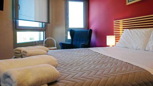 a bedroom with a large bed and a blue chair at Tessera Villas & Studios Collection in Gouvia