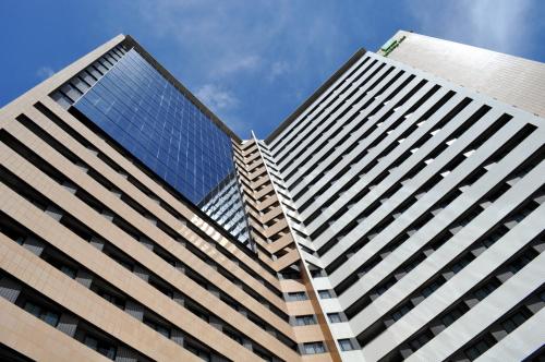 a view of two tall buildings looking up into the sky at Holiday Inn Fortaleza by IHG in Fortaleza