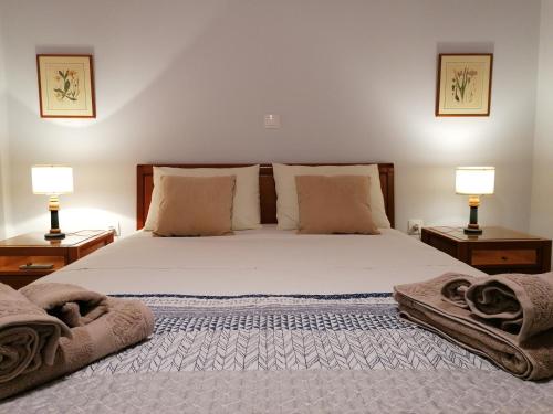 una camera da letto con un letto grande con due lampade di Vacation cozy home a Paralía Sergoúlas