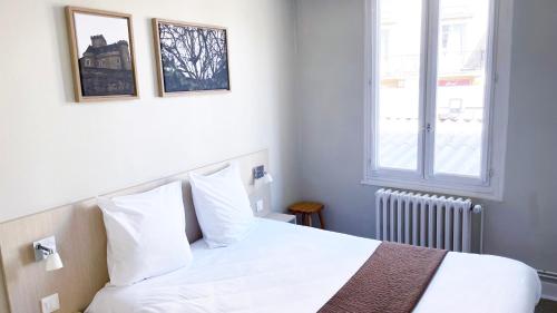 a bedroom with a white bed and a window at Abelha Hôtel Le France in Brive-la-Gaillarde
