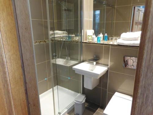 a bathroom with a glass shower and a sink at Riverside House in Callander