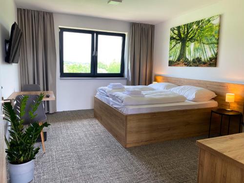 ヴァラシュスケー・メジジーチーにあるSport HOTEL Bečvaのベッドと大きな窓が備わるホテルルームです。