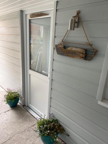 a door to a house with two potted plants next to it at Tiny Beach House in Saint Annes on the Sea