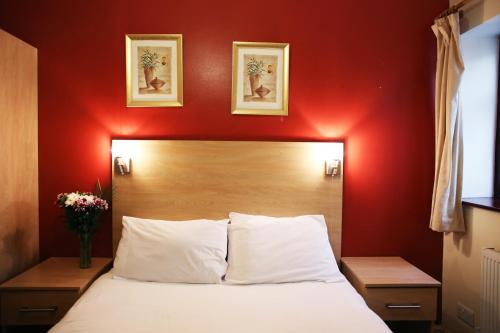 a bedroom with a bed with a red wall at City Inn Express Hotel in London