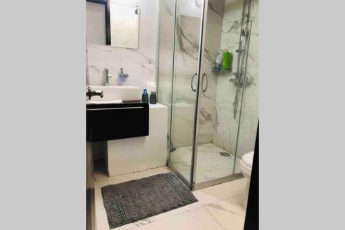 グアダラハラにあるCerca de plaza galerías, est chivas, Metropolitanoのガラスのシャワーと洗面台を備えたバスルーム