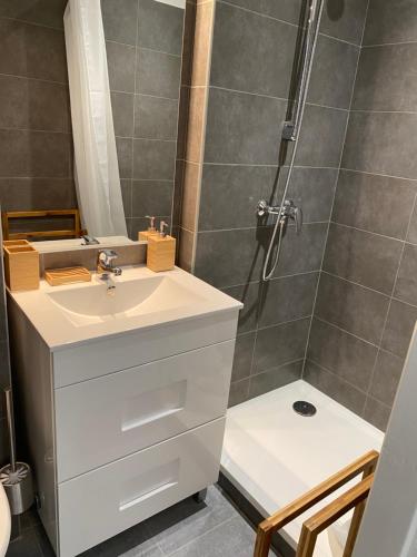 a bathroom with a white sink and a shower at Location de la Carraire in Valensole