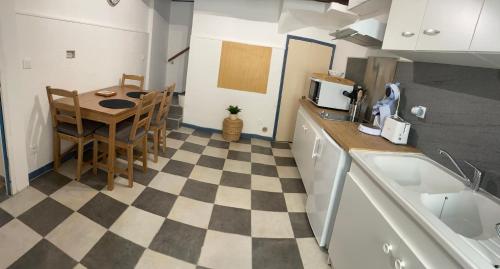 a kitchen with a table and a checkered floor at Location de la Carraire in Valensole
