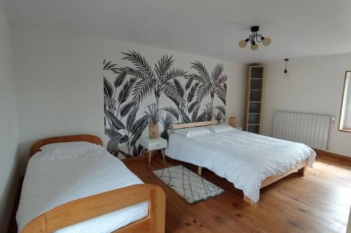 a bedroom with two beds and a wall mural at Gîte Les Hauts de Villemaloux in Dontreix