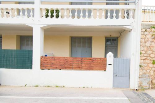 una casa blanca con una valla y una puerta en Le 92 Toulon Bas Faron en Toulon