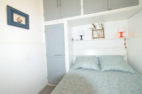 - une chambre avec un lit et un mur blanc dans l'établissement Le 92 Toulon Bas Faron, à Toulon