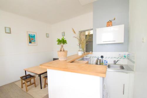 une cuisine avec des placards blancs et un comptoir en bois dans l'établissement Le 92 Toulon Bas Faron, à Toulon