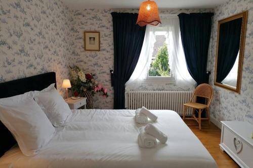 une chambre avec un lit blanc et une fenêtre dans l'établissement La roseliere Maison plain pied confortable belle décoration jardin magnifique 10 mn a pied centre ville Bayeux proche plages du débarquement, à Bayeux