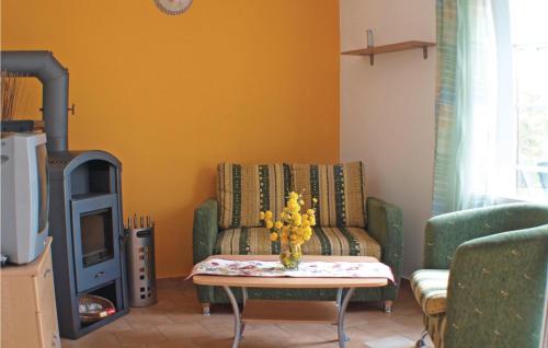 a living room with a couch and a table with flowers at Stunning Home In Fuhlendorf With Wifi in Fuhlendorf