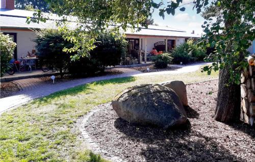 a rock sitting in the grass next to a tree at Stunning Home In Fuhlendorf With Wifi in Fuhlendorf