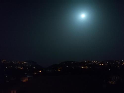 a view of the moon over a city at night at HedèraRooms in Agerola
