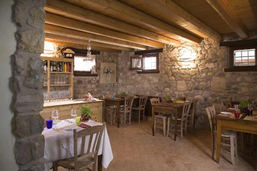 un restaurante con mesas y sillas y una pared de piedra en Agriturismo Althea, en Vittorio Veneto