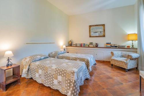 a hotel room with two beds and a chair at Casa Gege', for up to 5 guests, shared pool, Sorrento center in Sorrento