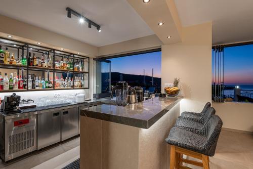 a kitchen with a bar with a view at Minois Boutique Hotel in Stalida