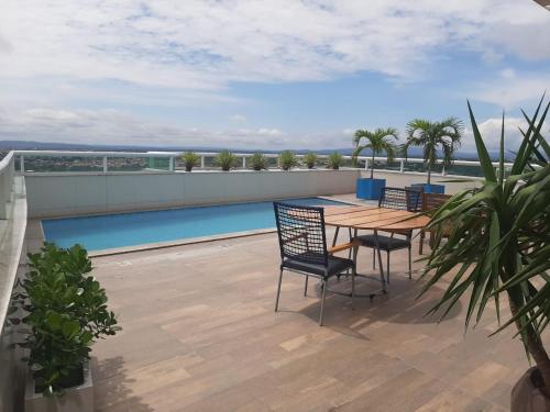 a patio with a table and chairs on a roof at Flat Kariris Home Service in Juazeiro do Norte