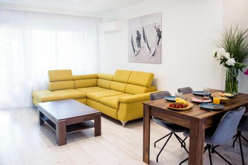 salon z żółtą kanapą i stołem w obiekcie South Part Zamárdi w Zamárdi